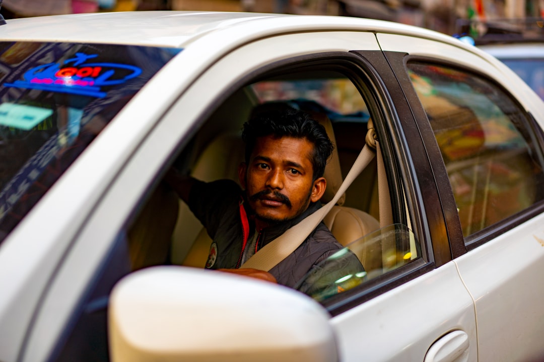 man in green shirt sitting inside car